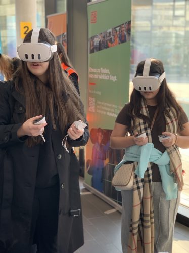 Zwei Mädchen* tragen eine VR Brille und Controller